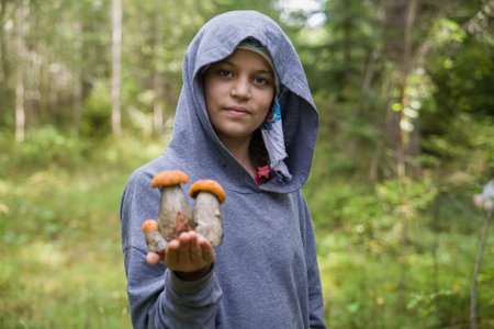 A European girl holds boletus mushrooms in her hands.の写真素材