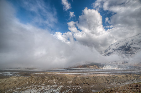 Low clouds float over a glacier in a mountain valley.の写真素材