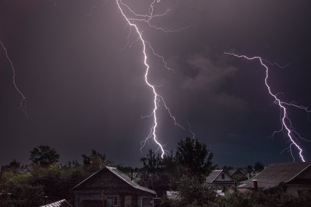 Thunderstorm lightning over residential buildings.の写真素材
