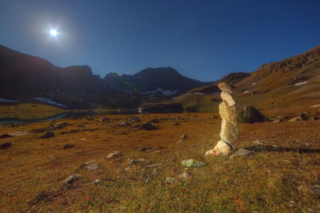 Ritual cairn. mountains in the background. Night, the moon is shining.の写真素材