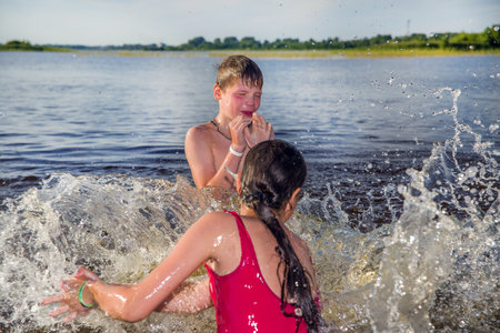 A boy and a girl are swimming in the lake.の写真素材