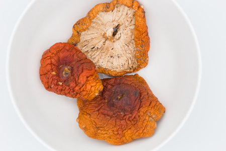 Dried red mushrooms on a white background.の写真素材
