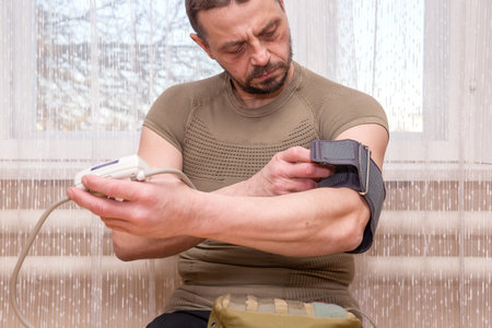 A 49-year-old European man measures his blood pressure.の写真素材