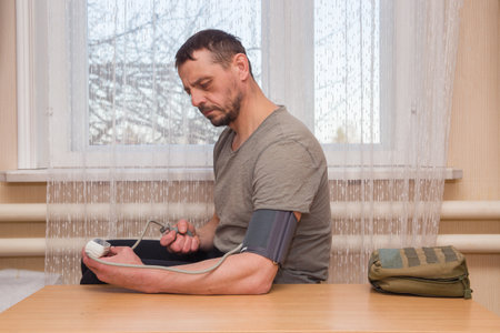 A 49-year-old European man measures his own blood pressure.の写真素材