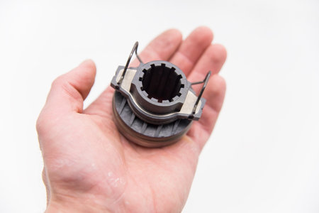 The hand holds the clutch release bearing.