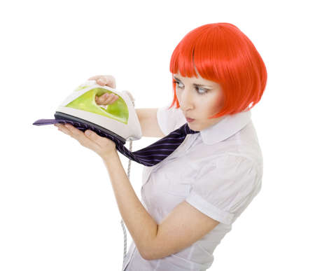 Serious woman ironing tie in formal clothesの写真素材