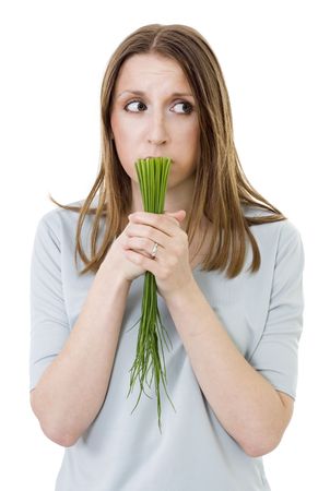 woried woman with onion holding bunch green onionの写真素材