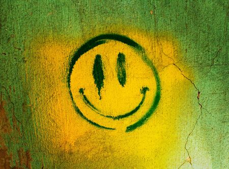 smiley on the concrete wall as background with white and greenの写真素材