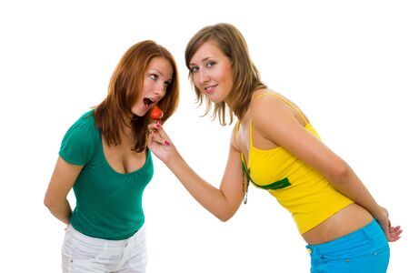 Two beautiful woman friends with strawberry in profileの写真素材