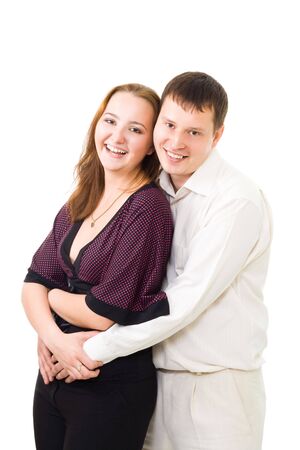 Young couple laughing embracing and looking at camrea isolated on whiteの写真素材