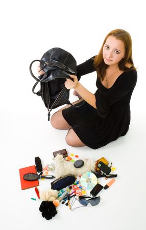 Sad woman looking in her hand bag with it's contents laying on the floor の写真素材
