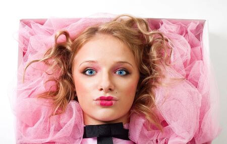 Face of a doll lay in box, stare at camera with blue eyes, isolatedの写真素材