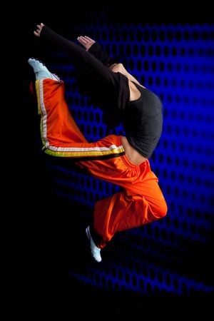 Woman dancer gymnast jumping on dark backgroundの写真素材
