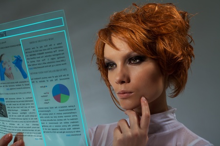 Future newspaper  - beautiful woman holding transparent futuristic monitor (shoot with professional makeup and hair stylist)の写真素材
