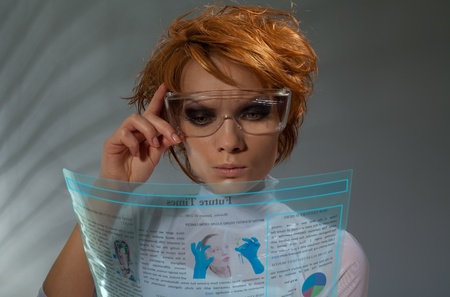 Futuristic beautiful woman reading Newspaper on transparent flexible screen(professional makeup and...