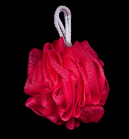 Pink bath sponge isolated on dark black backgroundの写真素材