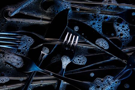 Bottom of the sink with forks, spoons, and soapの写真素材