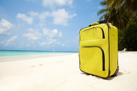 Suitcase on the Maldivian beach with white sand, sunny weather and palmsの写真素材