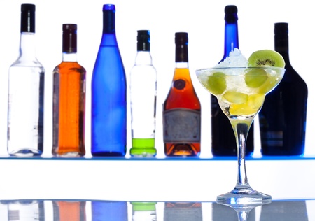 Cocktail glass with drink with bottles on the white bar backgroundの写真素材