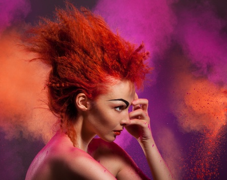 Beauty portrait of woman with color explosion made of color powderの写真素材