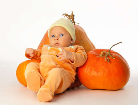 Little baby with pumpkins on whiteの写真素材