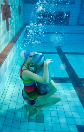 Young couple kissing underwater in the poolの写真素材