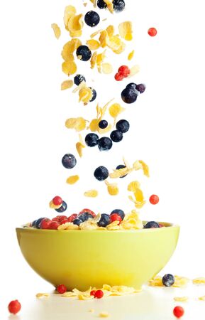 Flying to the bowl corn flakes with berries isolate on white