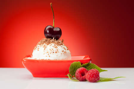 tasty ice cream ball with berries and cherry on topの写真素材
