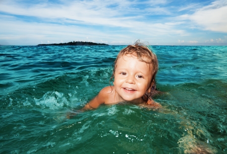 Happy two years old kid swimming in the sea waterの写真素材