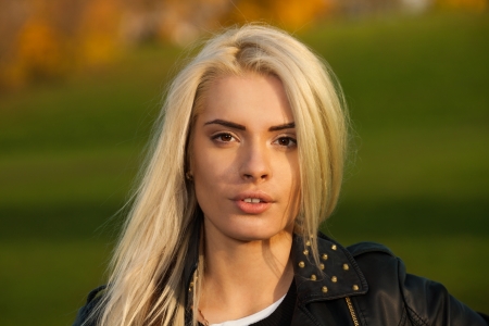 Long haired blond girl in the park looking at camera