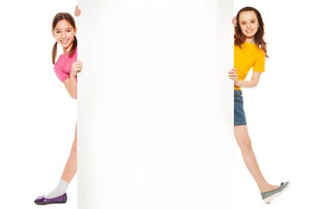 Two girls showing blank white board for advertising to be insertedの写真素材