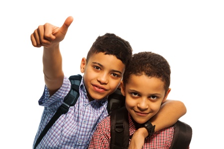 Two black boys after school with thumbs up and hugging each otherの写真素材