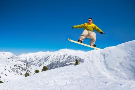 Cute handsome snowboard man in the air jumping in ski parkの写真素材