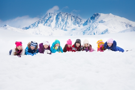 Large group of diversity looking kids 5-10 years old boys and girls on snow in a row day in mountainsの写真素材