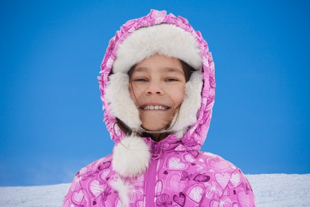 Face portrait of happy girl on winter day, wearing pink clothes