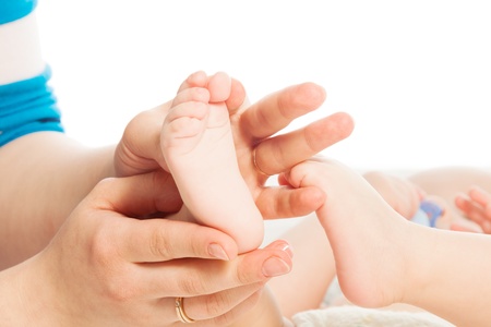 Mother massaging baby feet with her handsの写真素材