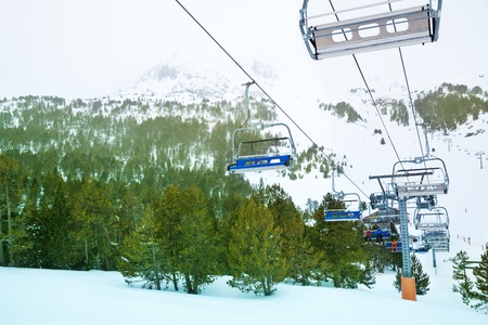 Ski lift in winter resort and landscape with the forest and mountain peaks on backgroundの写真素材