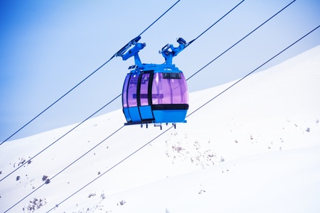 Closeup of cable car for lifting skiers and snowboarders over the mountain top and skyの写真素材