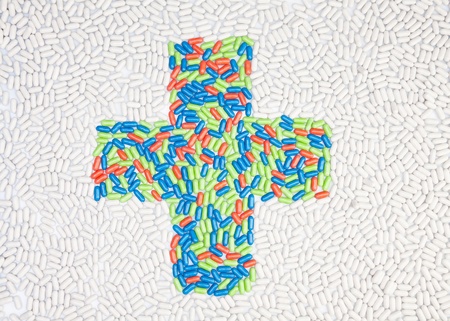 Medical cross symbol made of drug pills put into shape as mosaicの写真素材