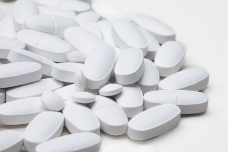 Pile of white long tablets laying on white tablet
