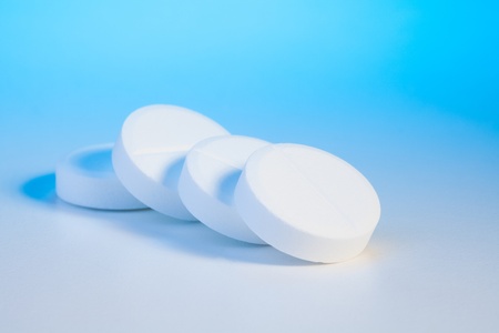 pile of big circle tablets drugs on blue table