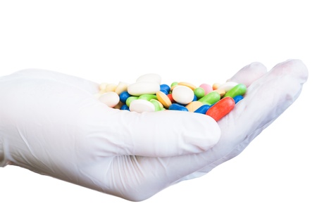 Hand full of different color pills in medical sterile gloves