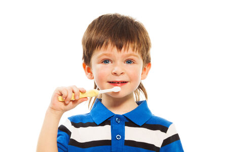 Close shoot of cute little three years old boy brushing his teeth isolated on white
