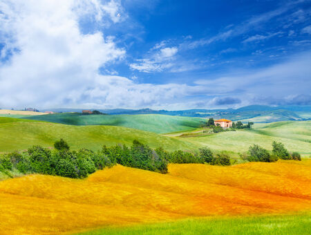 Golden field, hills and lonely house in Tuscany landscape, Italyの写真素材