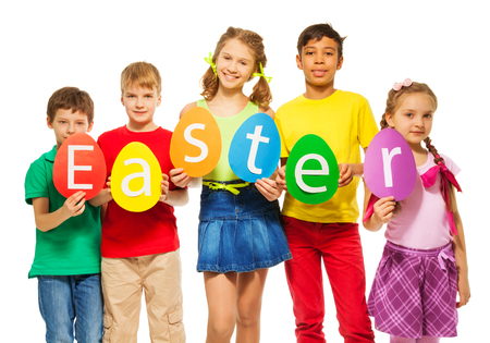 Children holding egg shape colourful cards with letters in a row making word Easter togetherの写真素材