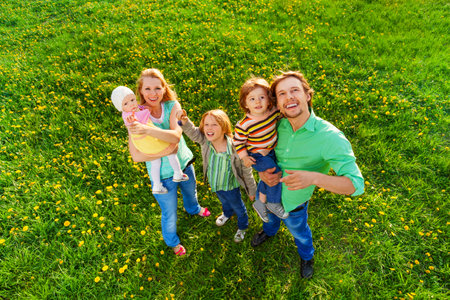 Smiling family portrait from above in park in summerの写真素材