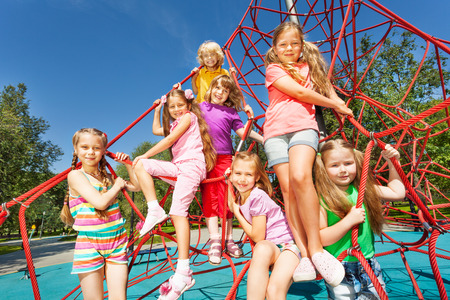 Smiling group of children sit on red ropesの写真素材