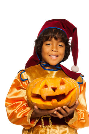 Boy in dwarf costume with carved pumpkin の写真素材