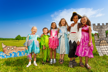 Kids diversity in costumes stand close and hugの写真素材