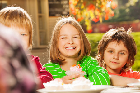 View of smiling girl and cute boy sitting outsideの写真素材